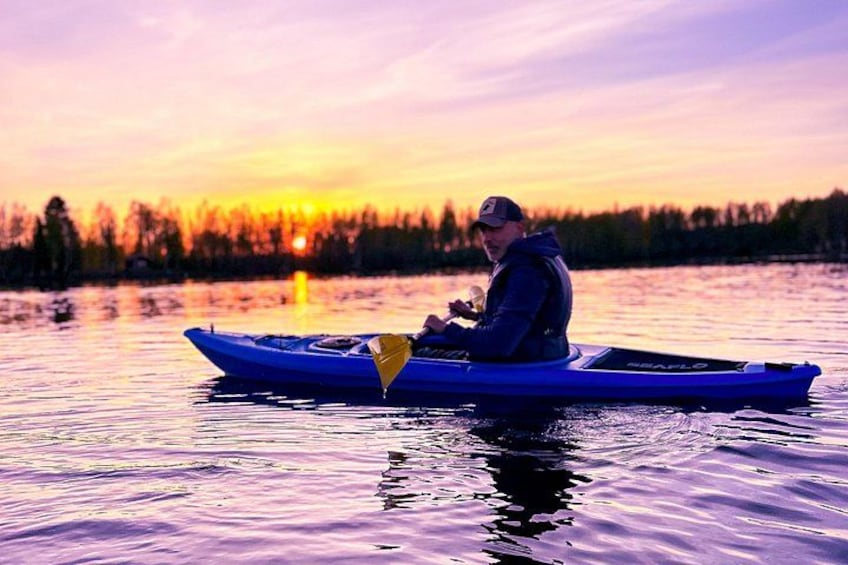 Una persona en kayak azul sobre aguas tranquilas durante la puesta de sol. 3