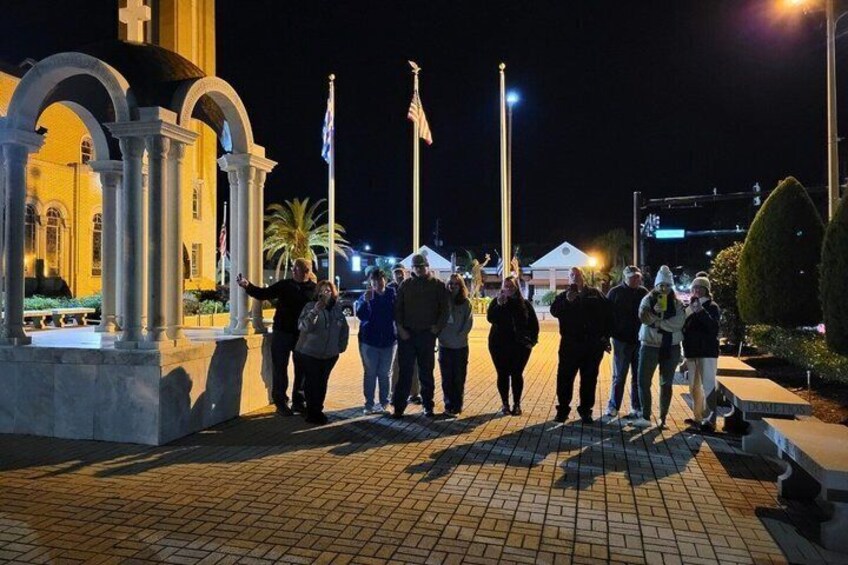 A group of people walking in front of a church at night. 3