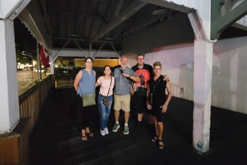 A group of people standing on a covered outdoor staircase. 5