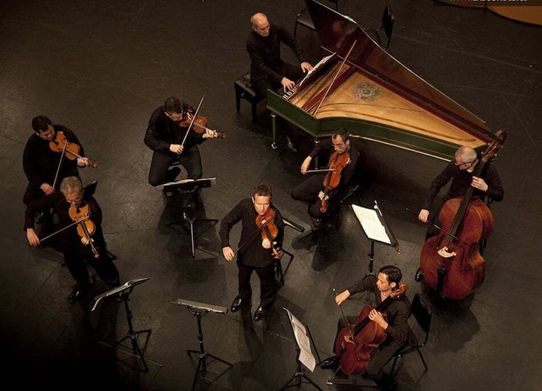 Ein Streichquartett mit Klavier und Kontrabass tritt auf einer Bühne auf. 1