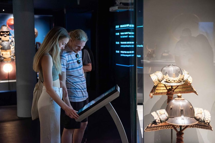 A museum exhibit with a digital display and a historical artifact. 4