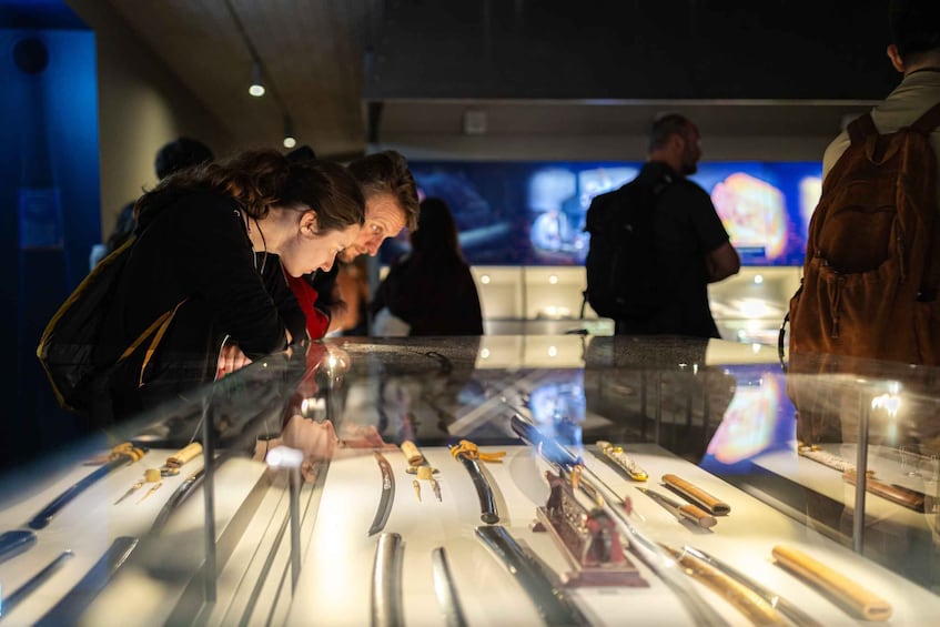 A display of various knives in a museum or exhibition setting. 5
