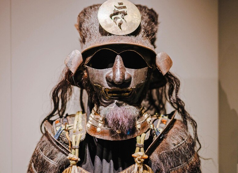 A statue with a mask, a headdress, and a necklace. 1