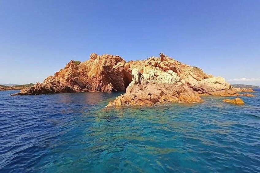 A rocky island with clear blue waters. 4
