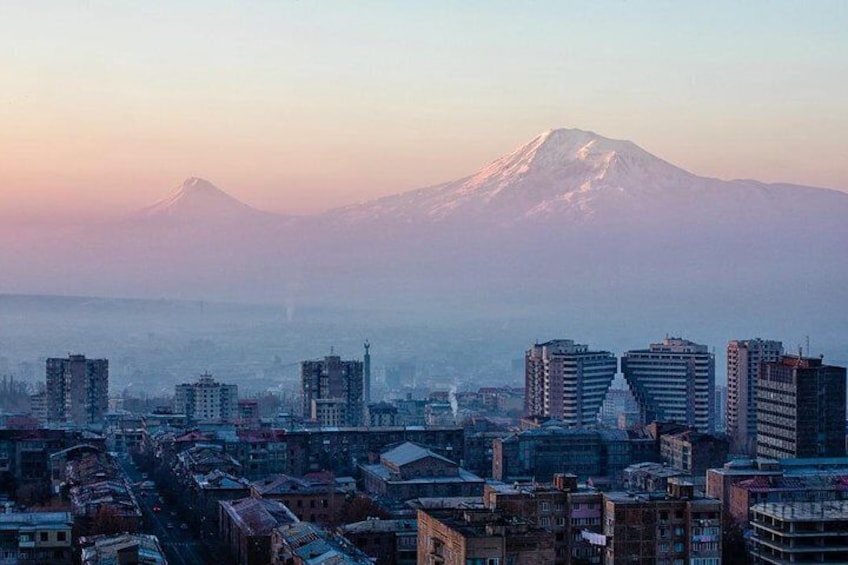A cityscape with a prominent mountain in the background. 1