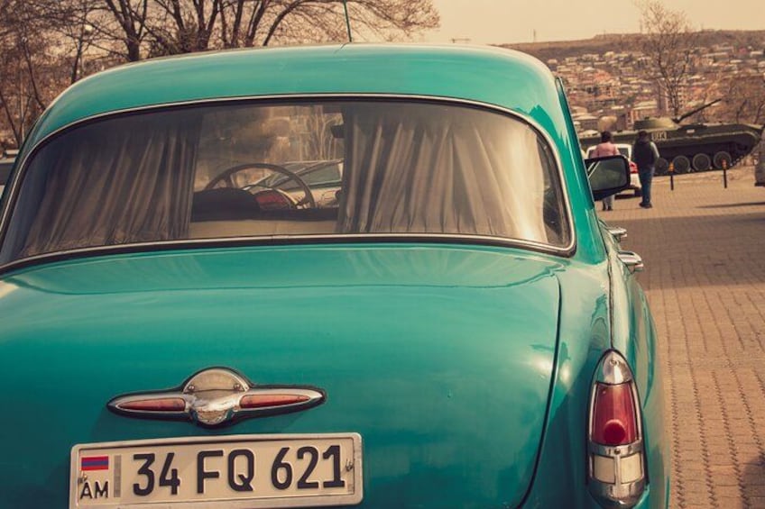 Un coche antiguo color aguamarina con una placa que dice 2