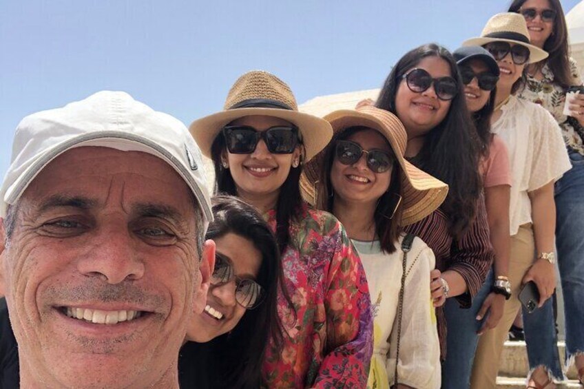 A group of people outdoors, some wearing hats and sunglasses. 3