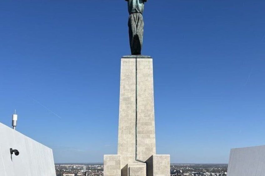 A statue on a pedestal with a clear sky in the background. 3