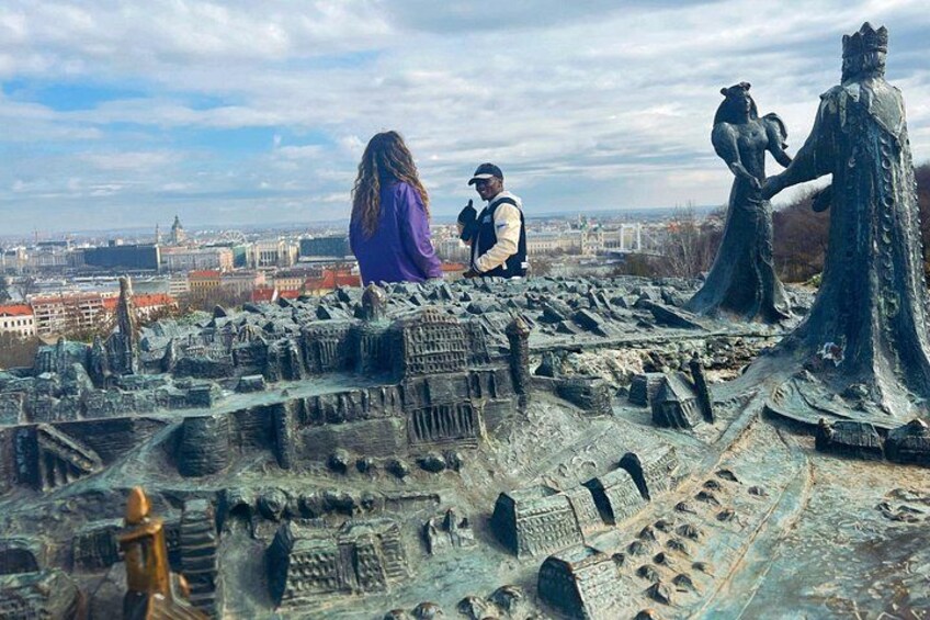 Ein detailliertes Modell einer Stadtlandschaft mit einer Statue einer Frau und eines Mannes, sowie einer Statue einer Figur, die ein Kind trägt. 4