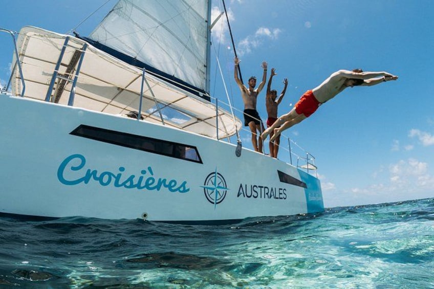 Un velero llamado Croisières con dos personas sumergiéndose en el agua. 2