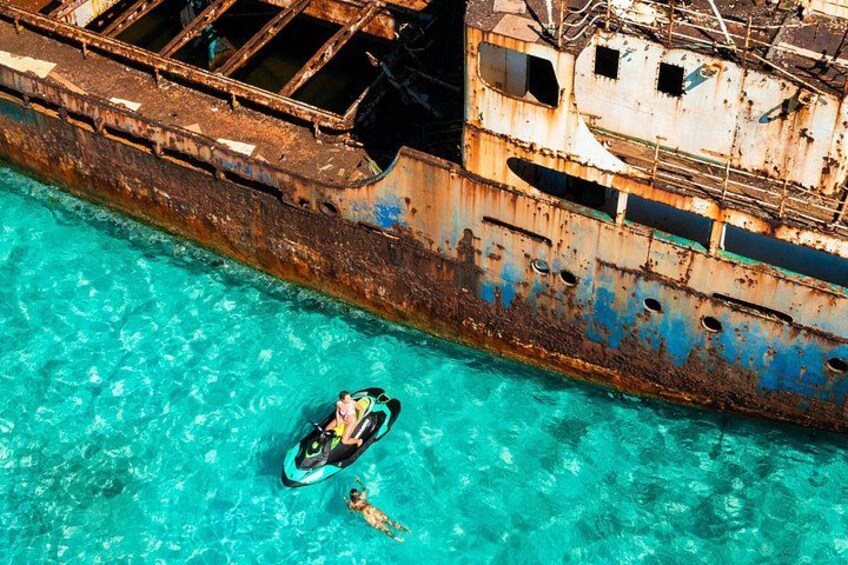 A large rusted shipwreck in clear turquoise water. 3