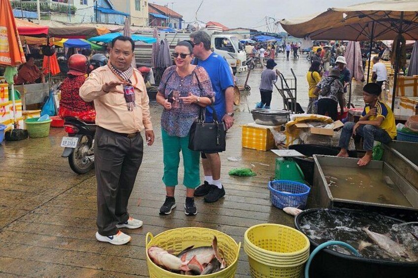 Un mercado animado con gente, puestos y mariscos exhibidos en cestas y recipientes. 5