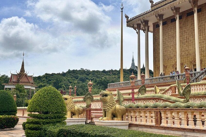 Un templo con arquitectura ornamentada, estatuas doradas y un jardín bien cuidado. 4