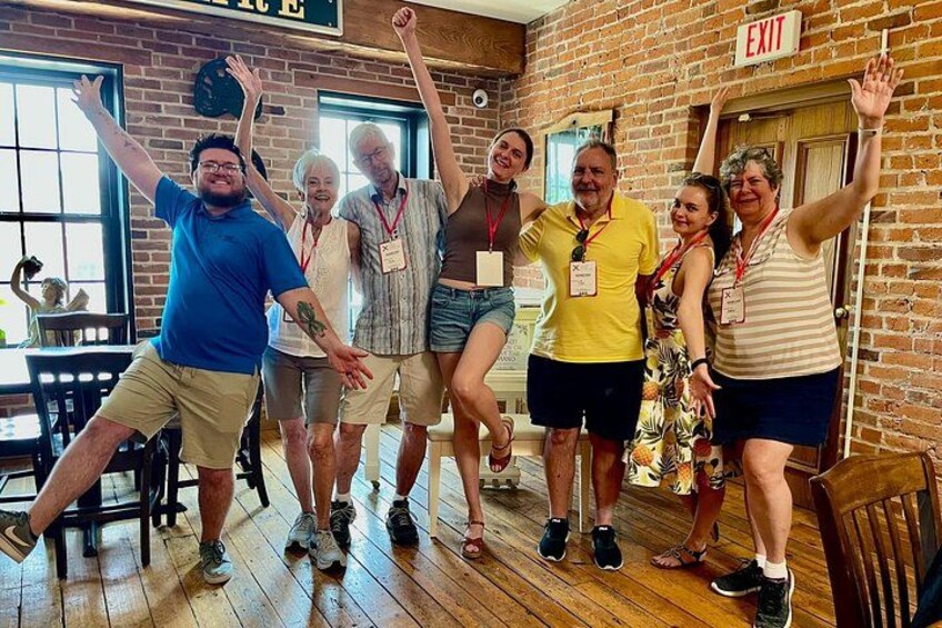 A group of people dancing in a room with brick walls and wooden floors. 5