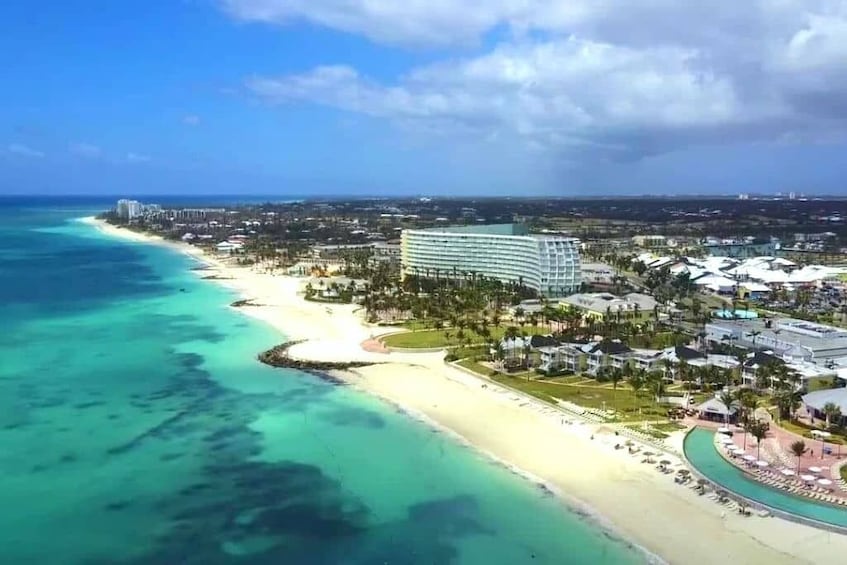 A coastal resort with a beach, ocean, and modern buildings. 1