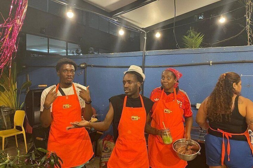 People in aprons, a kitchen counter, and a yellow chair. 4