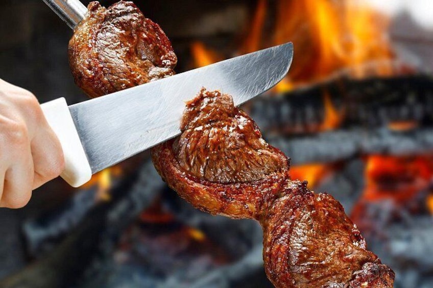 A person grilling meat over an open flame. 3