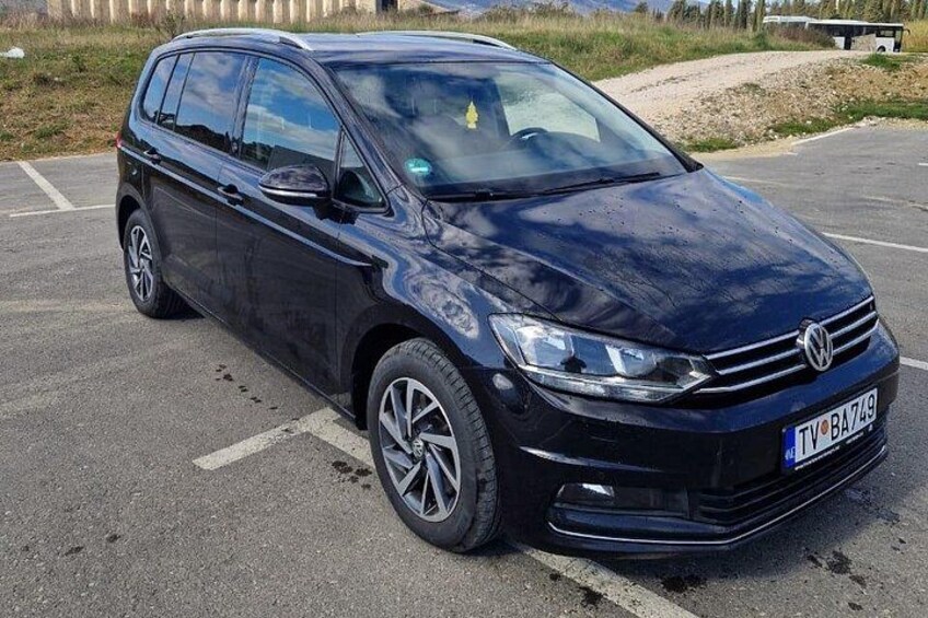 Een zwarte Volkswagen auto geparkeerd op een verharde ondergrond met een kentekenplaat. 3