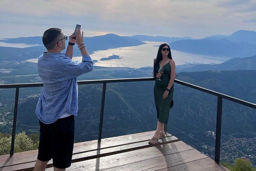 Een man maakt een foto van een vrouw op een balkon met een prachtig uitzicht op de bergen. 5