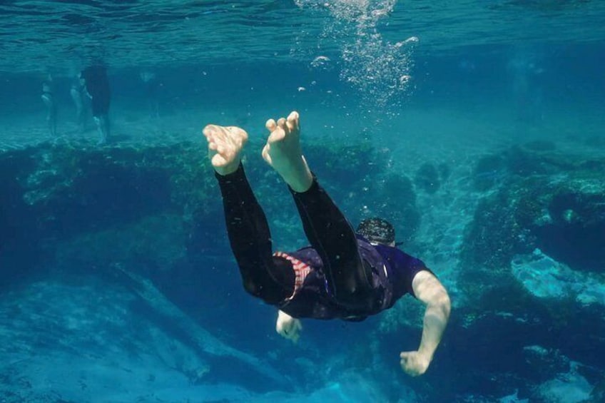A person swimming underwater in a pool. 5