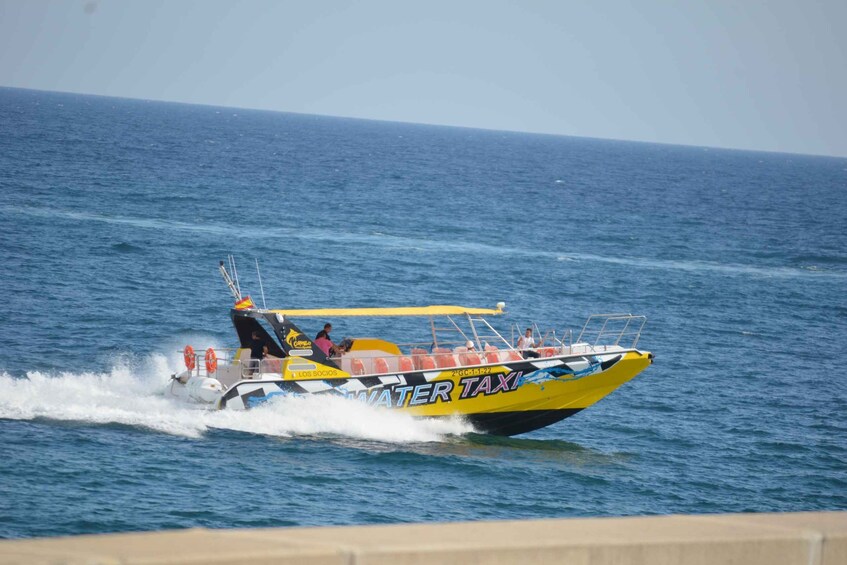 A yellow and black boat with 'WATER TAXI' written on it, moving on the water. 4