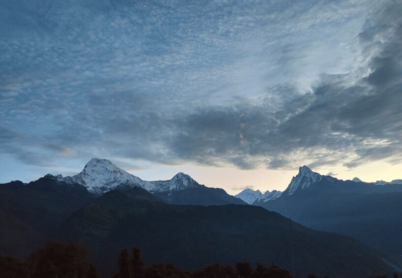 A mountain range with snow-capped peaks and a cloudy sky. 5