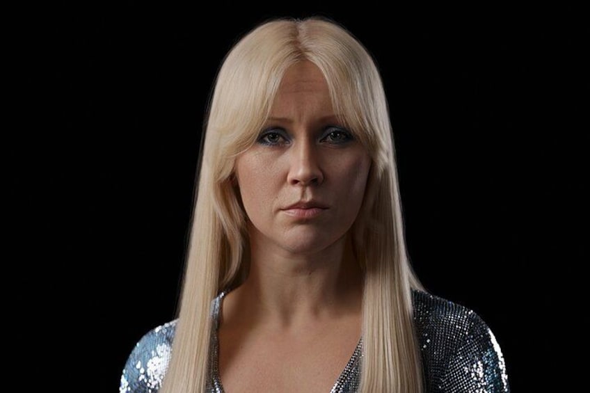 Une personne aux longs cheveux blonds, portant un haut brillant orné de paillettes. 5