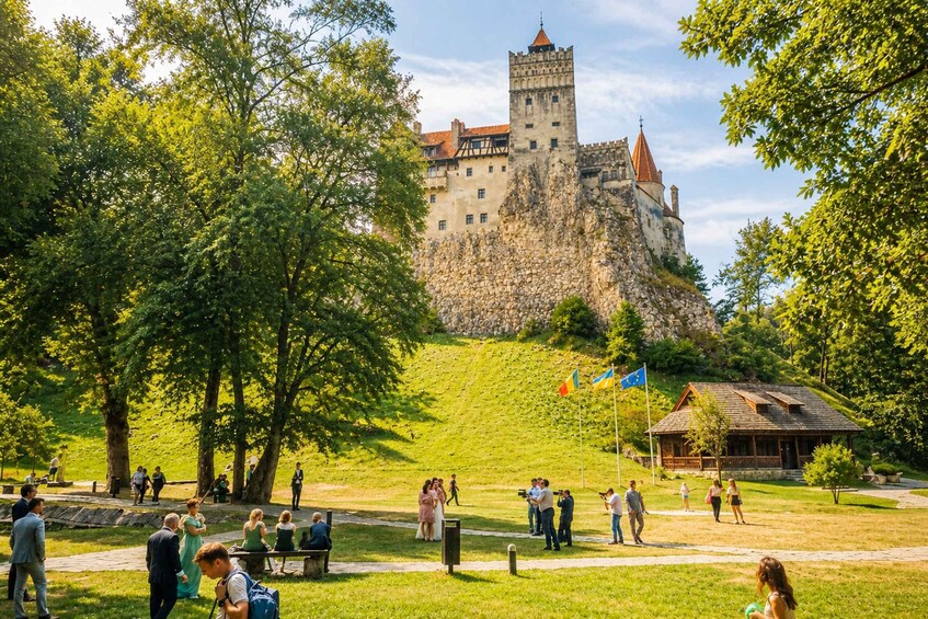 A castle on a hill with people walking and taking photos. 5
