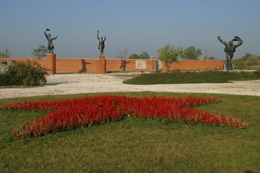 Een aangelegd gebied met beelden en rode bloemen. 4
