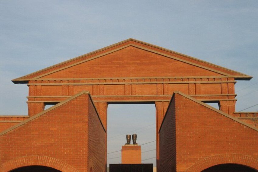 Een gebouw van baksteen met een driehoekige top en twee bogen. 3