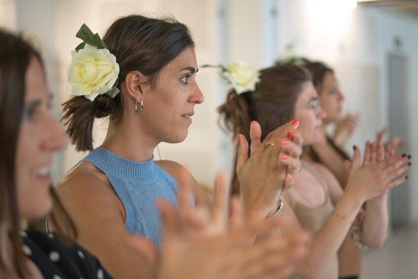 Une personne porte une fleur dans les cheveux et un haut bleu, et elle applaudit. 4