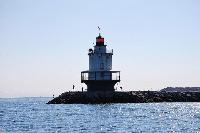 Un faro sobre un promontorio rocoso con aguas tranquilas. 2