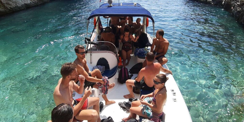 A group of people on a boat in clear water. 2