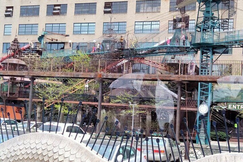 A playground with slides and climbing structures, a Ferris wheel, and a building with multiple windows in the background. 2