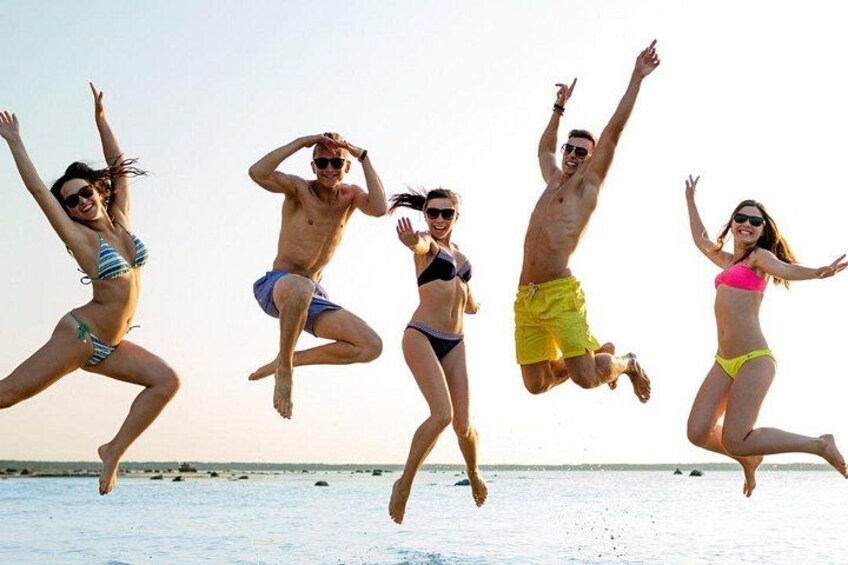 People jumping into the water at a beach. 2