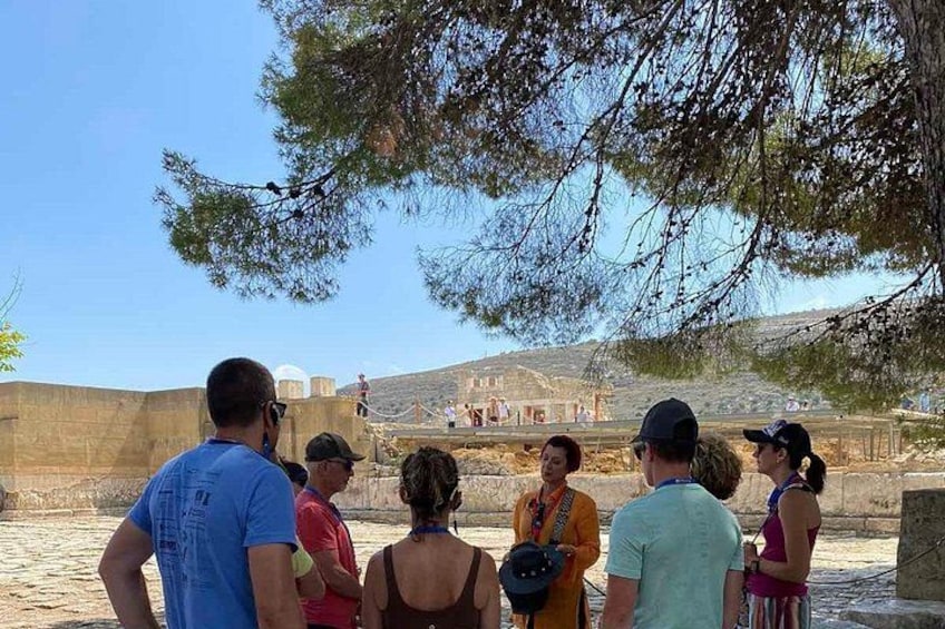 A group of people observing a historical site with ruins and a clear sky. 3