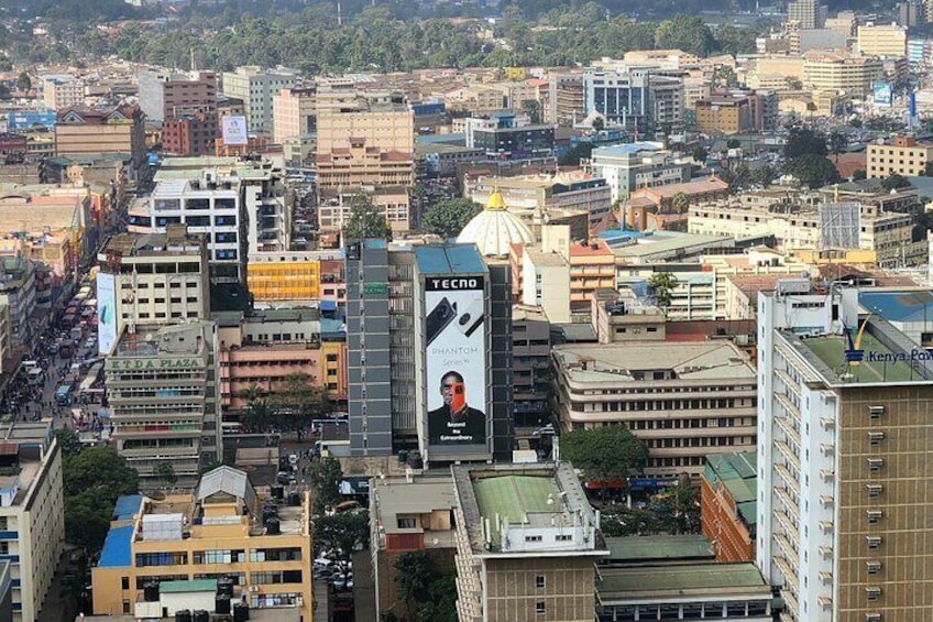 Vista urbana con un cartel llamativo que muestra a un hombre y el texto "TECHNO CHARTER". 3