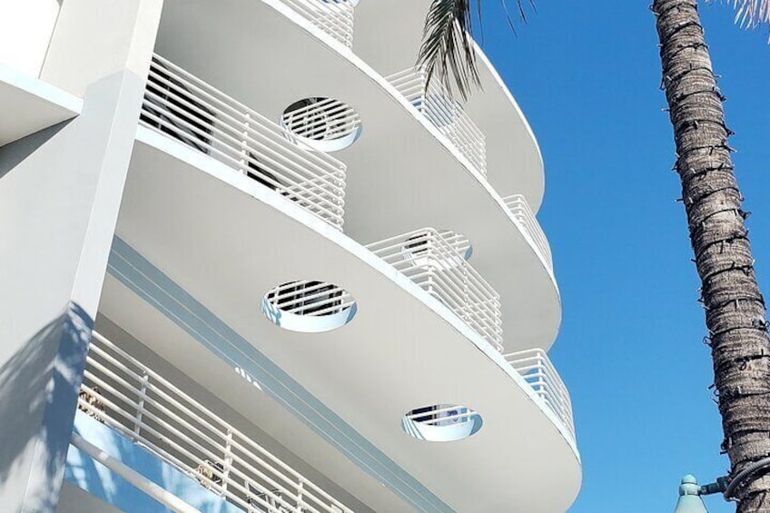 A multi-story building with balconies and circular windows. 2