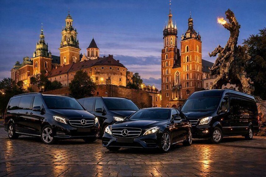 Een rij Mercedes-Benz voertuigen geparkeerd voor een historisch gebouw met meerdere torens en een standbeeld. 3