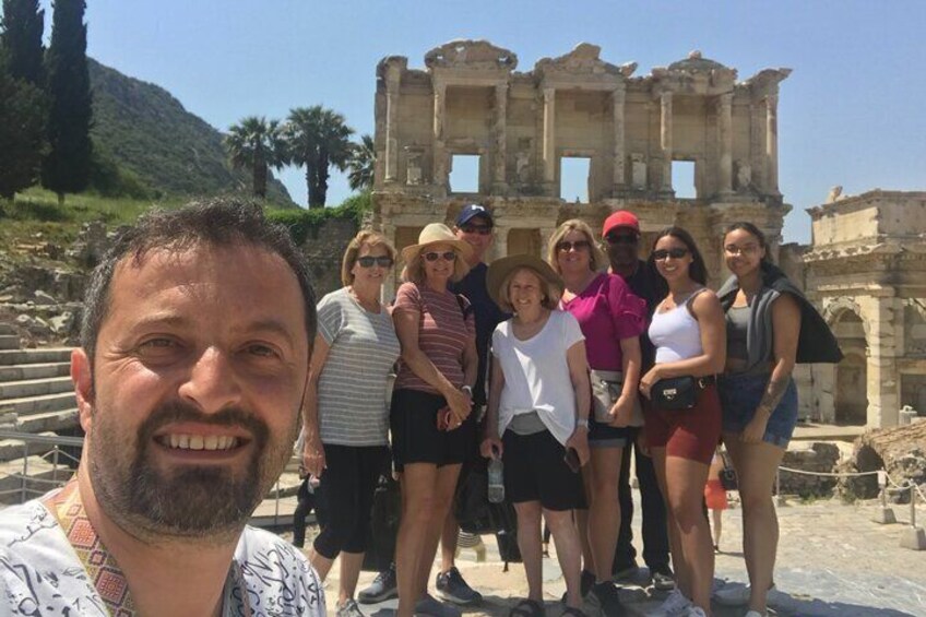 A group of people standing in front of ancient ruins with columns and steps. 1