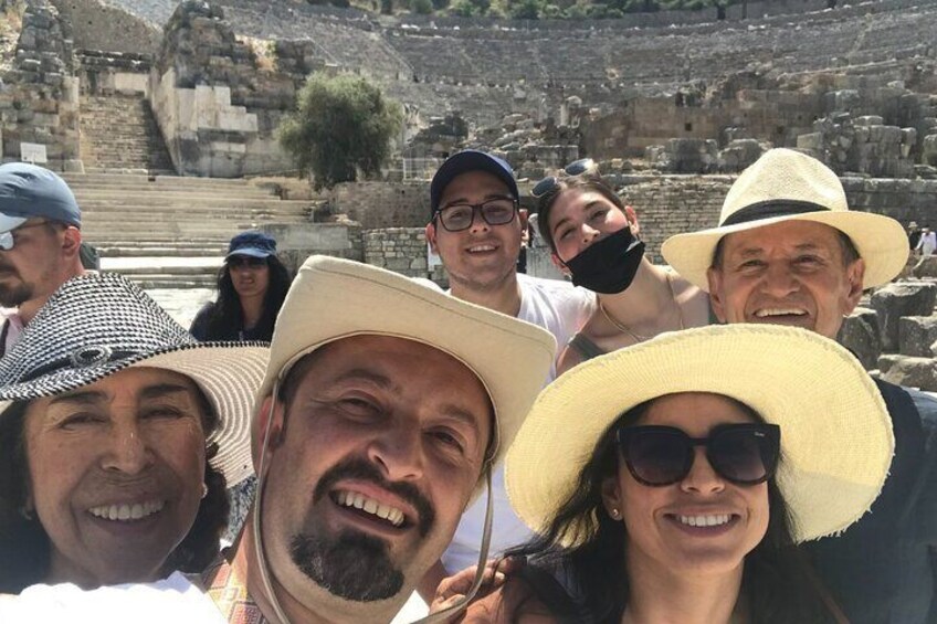 A group of people at an archaeological site with ancient ruins in the background. 5
