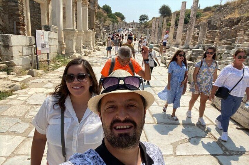 A historical site with ancient ruins and visitors walking along a stone pathway. 2
