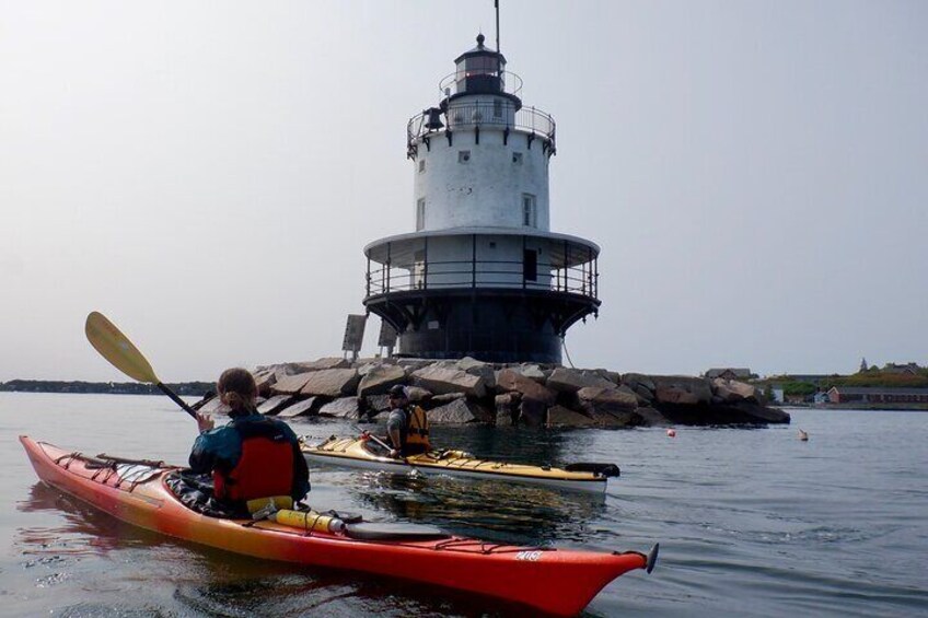 Une personne pratiquant le kayak près d’un phare. 2
