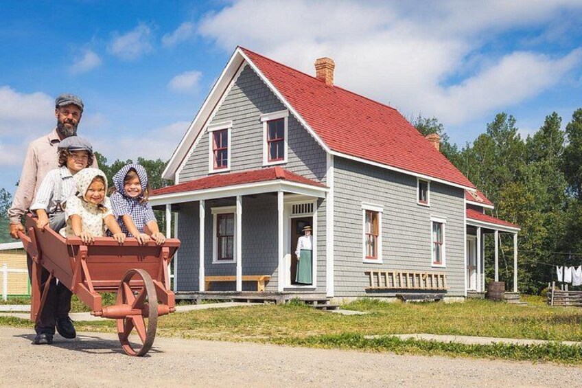 A historic house with a red roof, a porch, and a wooden cart. 4