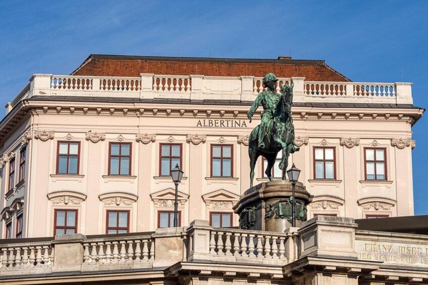 A building with the name 'ALBERTINA' and a statue of a man on horseback. 2