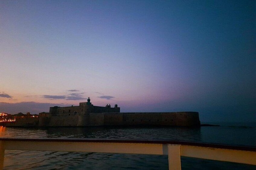 Une fortification côtière au crépuscule, avec une mer calme et un ciel dégagé. 3