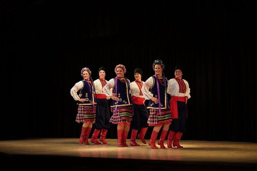 A group of people in traditional costumes on a stage. 3