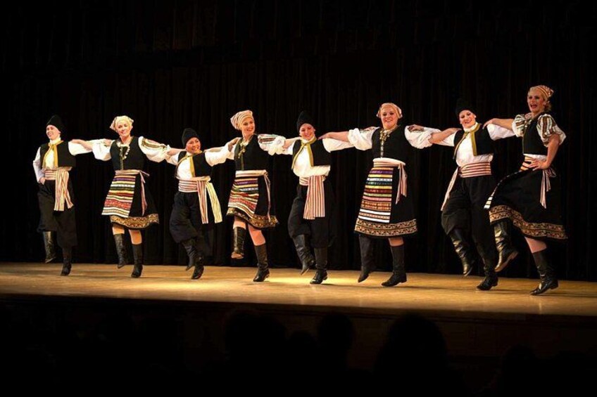 A group of dancers in traditional costumes performing on a stage. 4