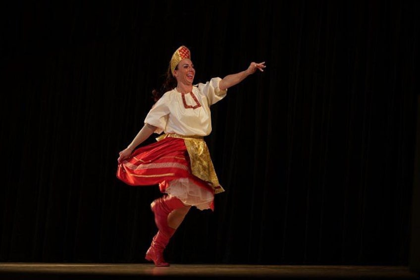 A person in traditional attire performing a dance on a stage. 4