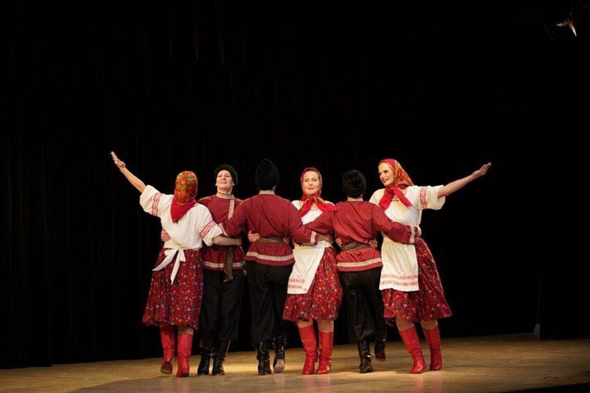 A group of people in traditional costumes on a stage. 2